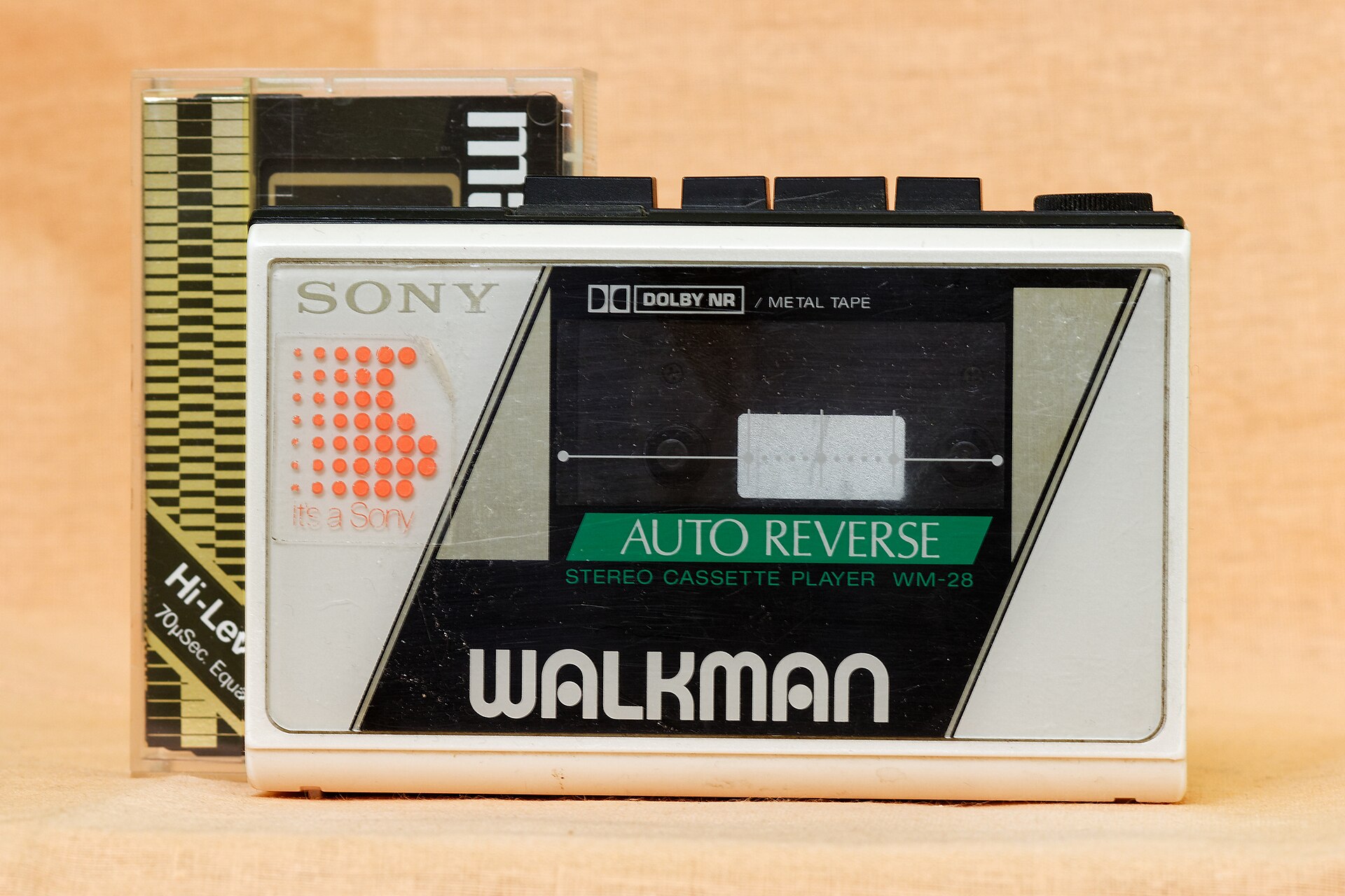 Sony Walkman WM-28 portable cassette player on a tan background